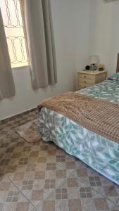 a bedroom with a bed and a window at Quarto próximo ao Lago do Major in Atibaia