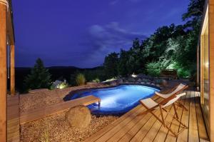 a backyard with a pool and two chairs and a deck at Sauna House Zelené Údolí in Rabyně