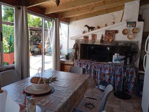 a dining room with a table and a television at Bed and Breakfast Omas Huisje in Ciudad de la Costa