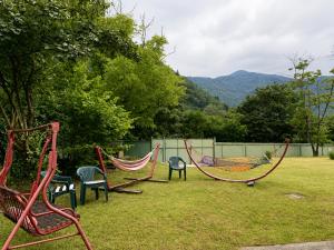 two hammocks in a yard with chairs and trees at Vintage 4BR Borjomi Hideaway in Borjomi