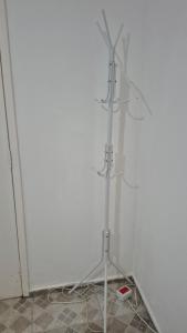 a metal stand in a room with a white wall at Quarto próximo ao Lago do Major in Atibaia