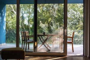 a glass door leading to a patio with a table and chairs at Willow Nest in Balatonfůzfő