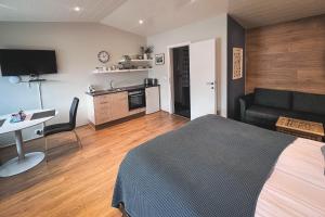 a bedroom with a bed and a desk and a kitchen at Thoristun Apartments in Selfoss