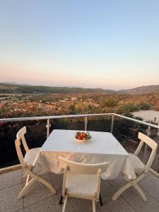 a table and chairs on a balcony with a bowl of fruit at Kindya Stone House in Kemikler
