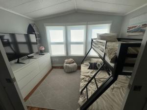 a dorm room with a bunk bed and a television at Sherkston Shores Cottage in Port Colborne +4 photos