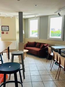 a living room with a couch and tables at Hôtel Inn Design Montluçon in Montluçon
