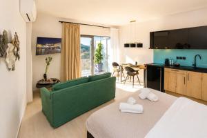 a living room with a green couch and a kitchen at Ermou w Jacuzzi Acropolis View Monastiraki in Athens