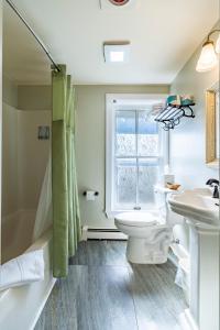 a bathroom with a toilet and a sink and a window at Sylvan Inn Bed & Breakfast in Glen Arbor +66 photos