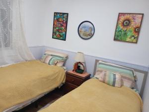 a bedroom with two beds and a clock on the wall at Bed and Breakfast Omas Huisje in Ciudad de la Costa