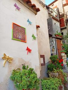 a wall with plants and butterflies on it at Eco Ostello Grisolia in Grisolia