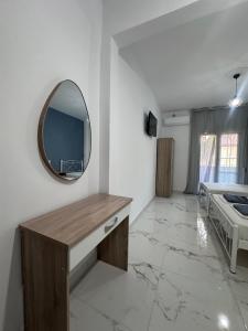 a bathroom with a mirror on the wall and a sink at Olympus Apartments in Paralia Katerinis