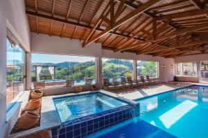 a large swimming pool with a view of the mountains at Pousada Estância das Montanhas Boutique in Águas de Lindoia
