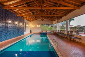a swimming pool in a house with a large window at Pousada Estância das Montanhas Boutique in Águas de Lindoia