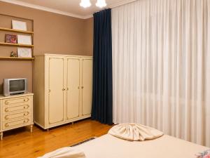 a bedroom with a bed and a dresser and a television at Vintage 4BR Borjomi Hideaway in Borjomi
