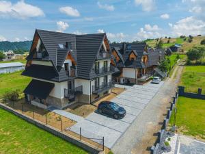 a row of houses with a car parked in the driveway at Stacja Tatry in Poronin