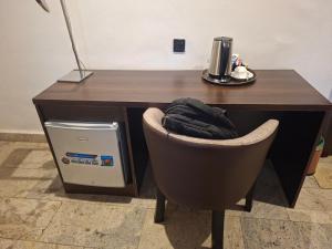 a desk with a chair in front of a desk with a cpu at Danville Hotel Ltd in Freetown