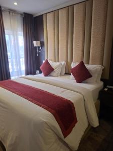 a hotel room with two beds with red and white pillows at Danville Hotel Ltd in Freetown