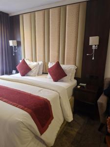 a hotel room with two beds with red and white pillows at Danville Hotel Ltd in Freetown