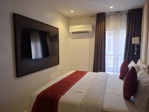 a hotel room with a bed and a flat screen tv at Danville Hotel Ltd in Freetown +1 photo