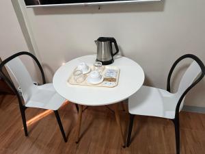 ein weißer Tisch mit zwei Stühlen und einem Teekessel darauf in der Unterkunft SouthPark Hotel Naga in Concepcion