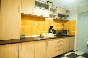 a kitchen with wooden cabinets and a sink at Elite Apartament Hunedoara in Hunedoara