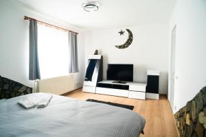 a bedroom with a bed and a flat screen tv at Elite Apartament Hunedoara in Hunedoara