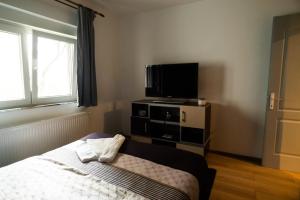 a bedroom with a bed and a flat screen tv at Elite Apartament Hunedoara in Hunedoara