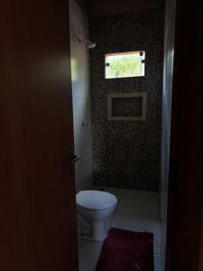 a bathroom with a toilet and a window at Aconchego Da Serra in Triunfo