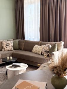 a living room with a brown couch and tables at Kalan Boutique Stay in Žirovnica