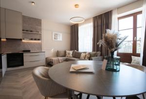 a kitchen and living room with a table and a couch at Kalan Boutique Stay in Žirovnica