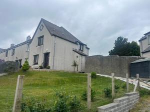 a white house with a fence in front of it at 60 Springfield Road in Stornoway