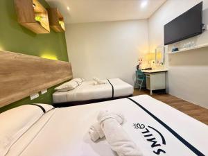 a hotel room with two beds and a desk at Smile Hotel Danau Kota in Kuala Lumpur