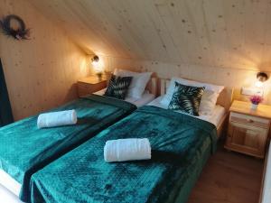 a room with two beds and two night stands at Górska Przystań in Grywałd