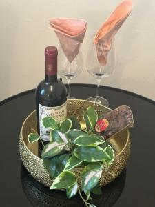 a bottle of wine and two glasses and a plant at Gästehaus in Kronshagen