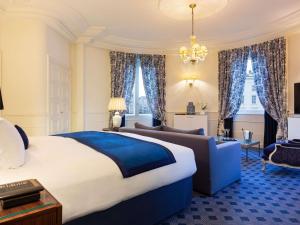 a bedroom with a large bed and a couch at Le Royal Hotel Lyon - MGallery Collection in Lyon