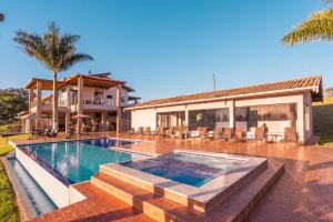 a house with a swimming pool in front of a house at Pousada Estância das Montanhas Boutique in Águas de Lindoia