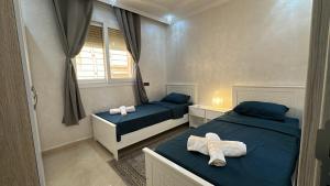 a bedroom with two beds and a window at Appartement Agadir Tilila 1 pour couples mariés et familles in Agadir