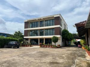 a building with a car parked in a parking lot at Ma Room Place Sukhothai Resort in Sukhothai