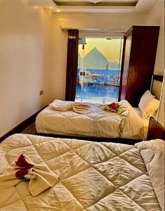 two beds in a room with a view of the ocean at malak pyrameds rofe top in Cairo