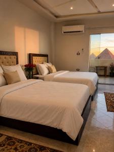 a hotel room with two beds and a window at malak pyrameds rofe top in Cairo