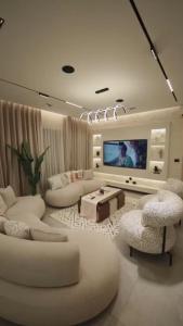 a living room with white furniture and a flat screen tv at مدينتي برافادو in Madinaty