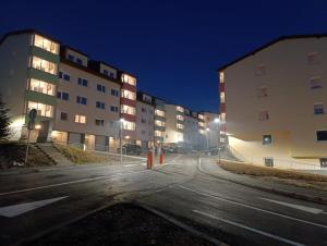an empty street in front of a building at night at The Olive Branch in Sarajevo