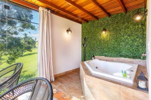 a bath tub in a room with a green wall at Pousada Estância das Montanhas Boutique in Águas de Lindoia