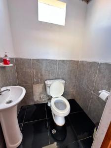 a bathroom with a toilet and a sink at Hospedaje Vista Ausangate in Labramarca