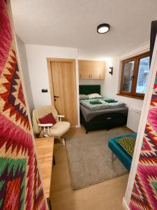 a small room with a bed and a chair at KOTA - Prime Location in Jahorina