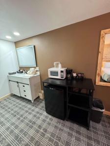 a room with a microwave on a desk with a sink at Suite 102 in Lusk