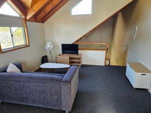 a living room with a couch and a table at Billungar Unit 1 at Hat Head - 1 Creek Street in Hat Head