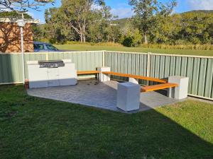 a picnic bench and a grill in a yard at Billungar Unit 2 at Hat Head - 1 Creek Street in Hat Head