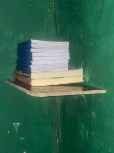 a stack of books sitting on a shelf at Least desirable room in Rwamagana