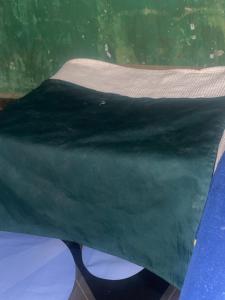 a green sheet on top of a table at Least desirable room in Rwamagana